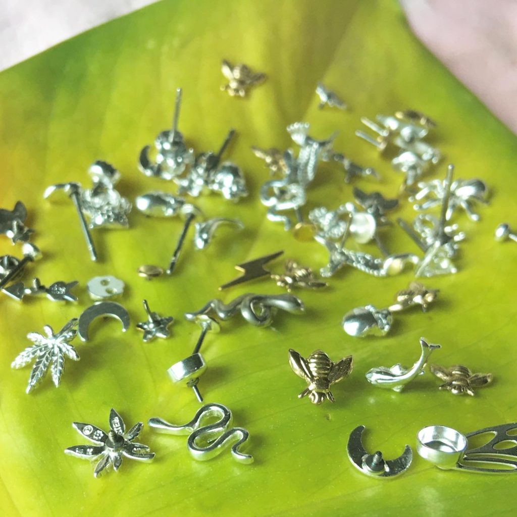 Many earrings sitting on a leaf